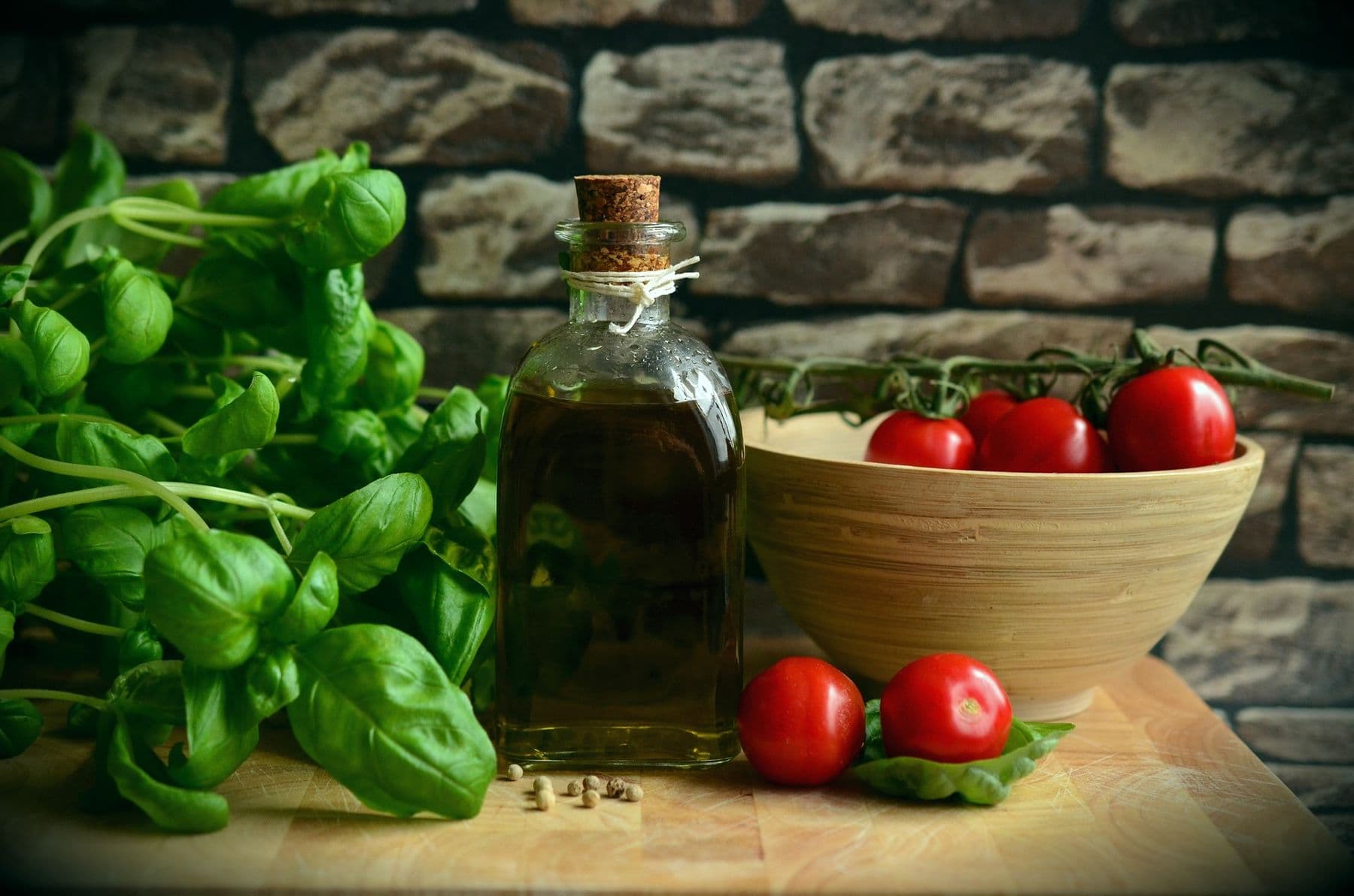Bottiglia di olio extravergine con basilico e pomodori